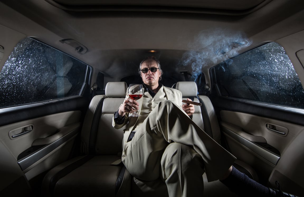 rich man in a white suit in the car, a millionaire with a cigar and a glass of alcohol